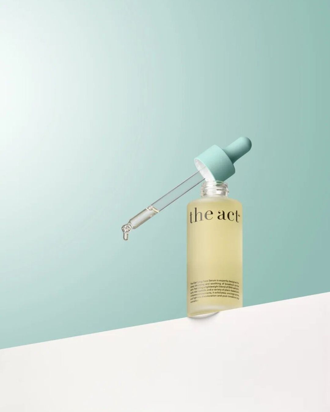 Clarifying Face Serum glass bottle against a green background