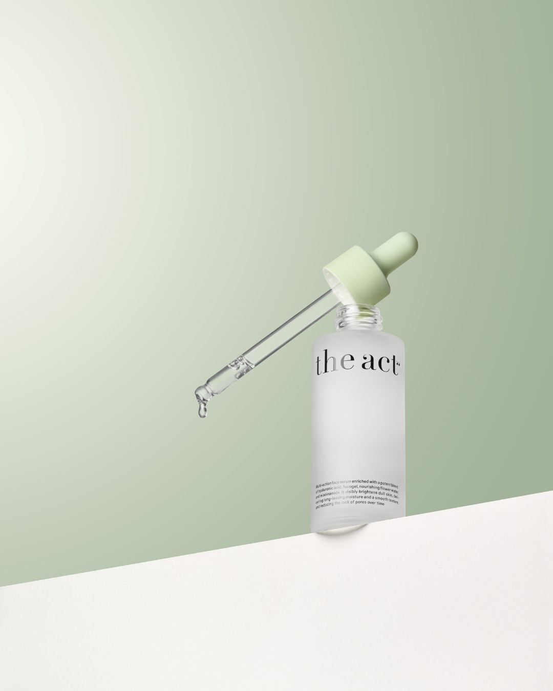 Skincare bottle with dropper labeled 'the act' on a light green background