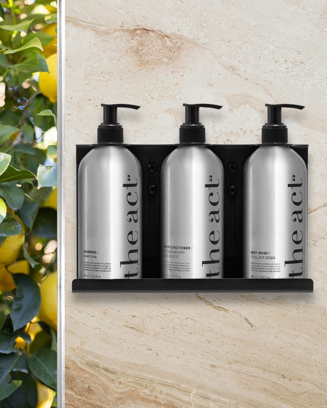 The Act shampoo, conditioner, and body wash bottles mounted in a wall dispenser holder in a hotel bathroom