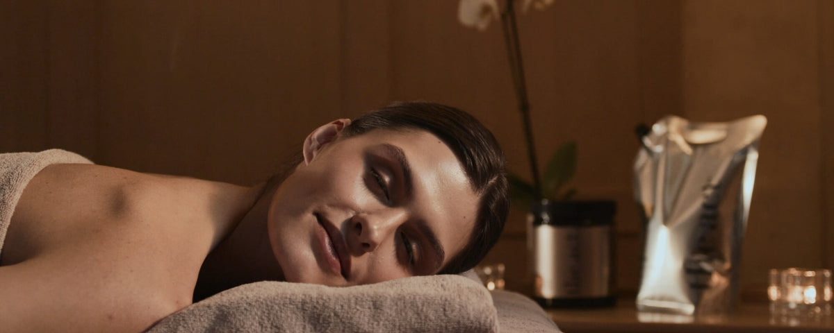 Hotel spa guest relaxing during a treatment, surrounded by The Act professional skincare range