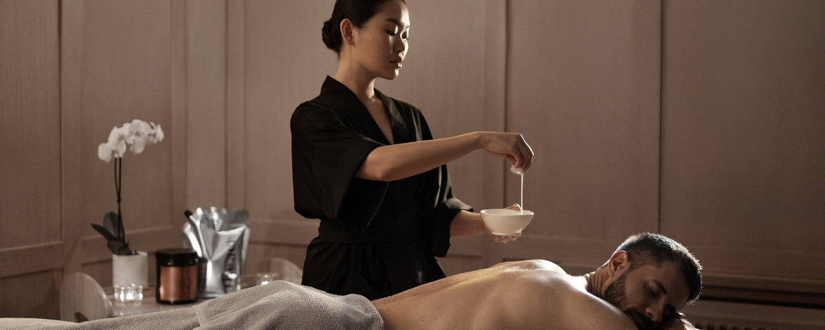 Spa therapist applying the Act massage oil and lotion to a client during a professional treatment session