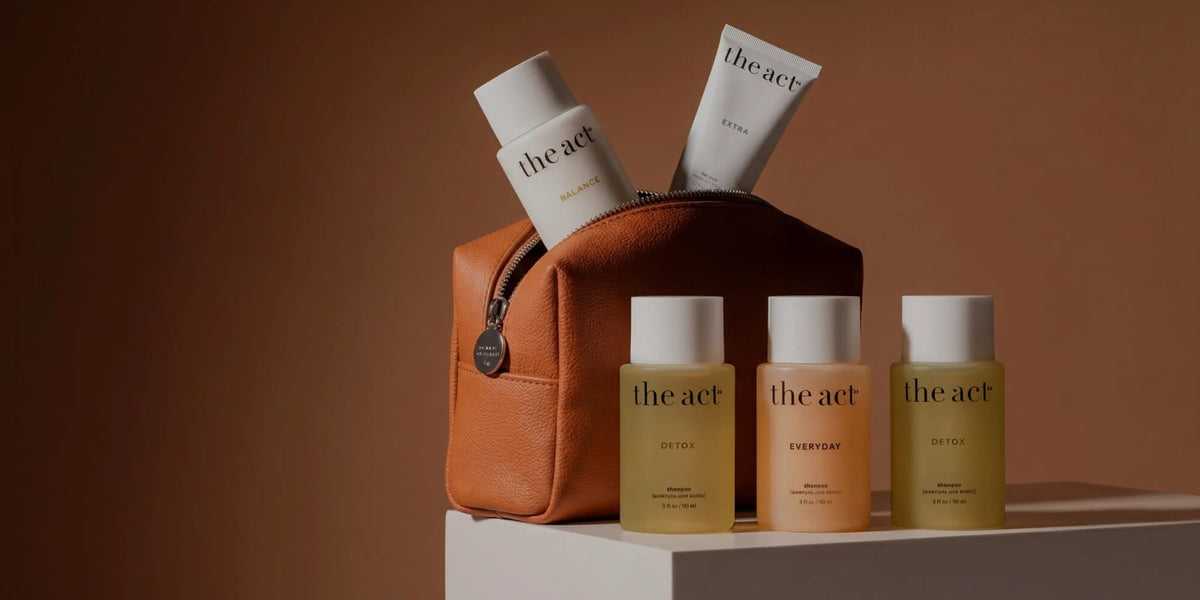 The Act retail hair care range featuring Detox and Everyday shampoos with Balance and Extra treatments displayed in a leather pouch