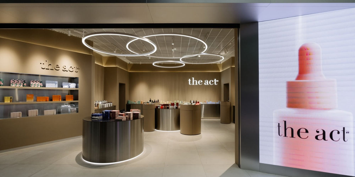 The Act branded retail store with product shelving and a featured serum bottle